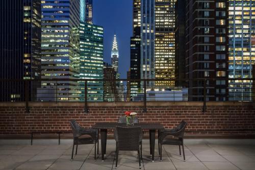a table and chairs with a view of a city skyline at Hotel 57 in New York
