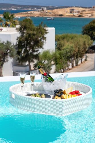 a white table with a bottle of champagne and some drinks at Lilly Residence-All Sea View Suites, Adults Only in Naousa