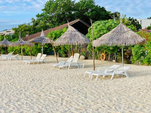 a group of chairs and umbrellas on a beach at ilaa Beach Maldives in Gulhi