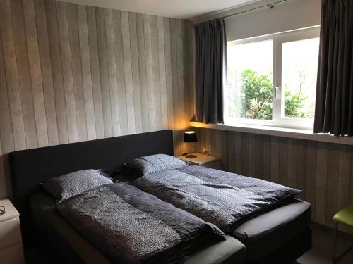 - un grand lit dans une chambre avec fenêtre dans l'établissement Fewo Klimduin Castricum, à Castricum