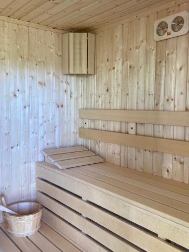 a sauna with wooden walls and a bucket in it at Villa Detelina in Sapareva Banya