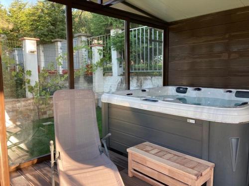 a jacuzzi tub sitting on a patio with a chair at Villa Detelina in Sapareva Banya