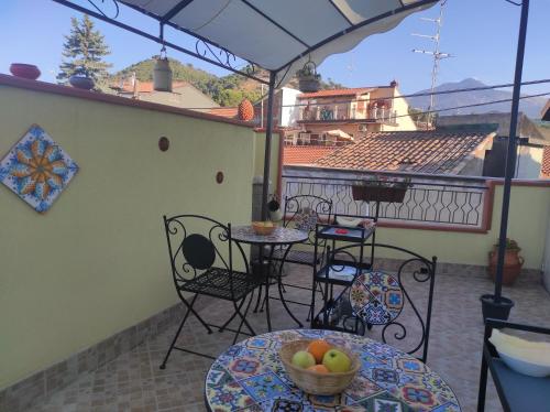 a balcony with tables and chairs and an umbrella at Dove nasce il Sole B&B in Nicolosi