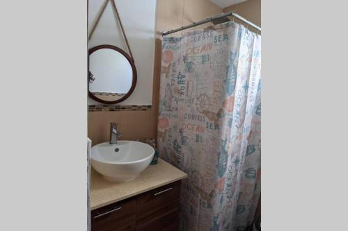 a bathroom with a sink and a shower curtain at El Muelle, Hermoso y cómodo apartamento in Monterrico