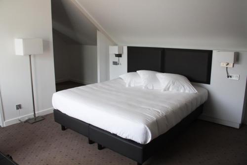 a bedroom with a large bed with white sheets at Loire & Sens in Juigné-sur-Loire