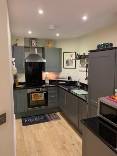 a kitchen with gray cabinets and a stove top oven at Minster View Apartment at Talbot Court, York in York