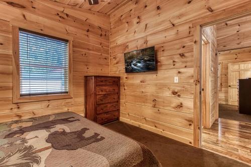 a bedroom with a bed in a wooden cabin at Ooglie Bear, Hot Tub, WIFI, Free Attraction Tickets!!! in Gatlinburg
