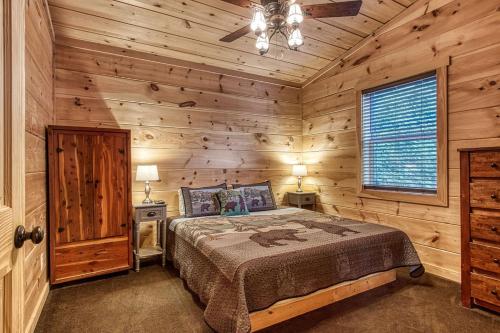 a bedroom with a bed in a log cabin at Ooglie Bear, Hot Tub, WIFI, Free Attraction Tickets!!! in Gatlinburg