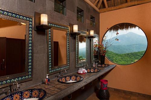 a bathroom with three sinks and two mirrors at El Corazón Golf & Spa Resort Manzanillo in Manzanillo
