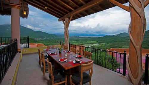a table and chairs on a balcony with a view at El Corazón Golf & Spa Resort Manzanillo in Manzanillo
