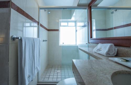 a bathroom with a shower and a sink and a mirror at Del Marques Hotel and Suites in Guadalajara