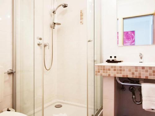 La salle de bains est pourvue d'une douche, de toilettes et d'un lavabo. dans l'établissement Gartenhotel LandArt, à Bad Soden-Salmünster