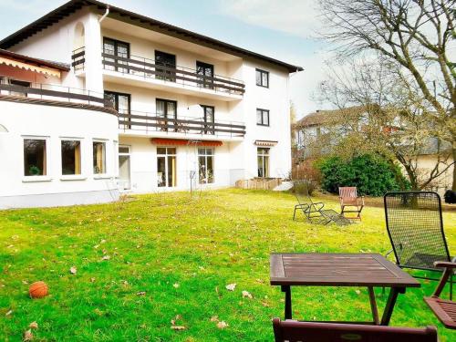 a house with a yard with a table in front of it at Gartenhotel LandArt in Bad Soden-Salmünster