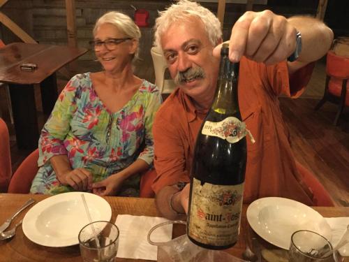 a man and a woman sitting at a table with a bottle of wine at Villa F&B in Bocas del Toro