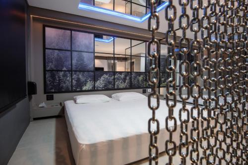 ein Schlafzimmer mit einem Bett und einem großen Fenster in der Unterkunft Motel Della Montagna (Adult Only) in Bento Gonçalves