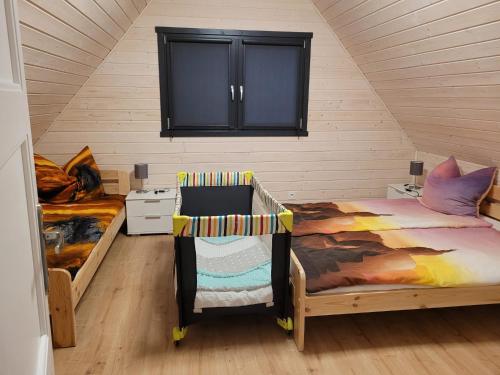 una camera mansardata con 2 letti e un armadio di San Escobar Dziwnówek a Dziwnówek