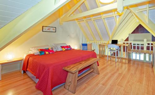 Schlafzimmer mit einem Bett mit einer roten Bettdecke in der Unterkunft Village Creole in Les Trois-Îlets