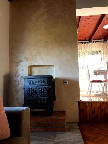 a fireplace in a living room with a chair and a table at Seosko turističko domaćinstvo "Klinačka priča" in Valjevo
