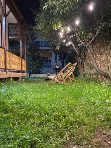 a wooden bench sitting in the grass in front of a house at Hnameni Stepanavan Guesthouse - Hotel in Stepʼanavan