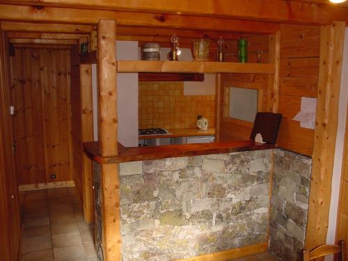 a kitchen with a stone fireplace in a cabin at Chalet Philippe in Peisey-Nancroix
