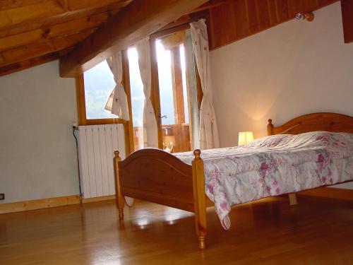 um quarto com uma cama e uma grande janela em Chalet Philippe em Peisey-Nancroix