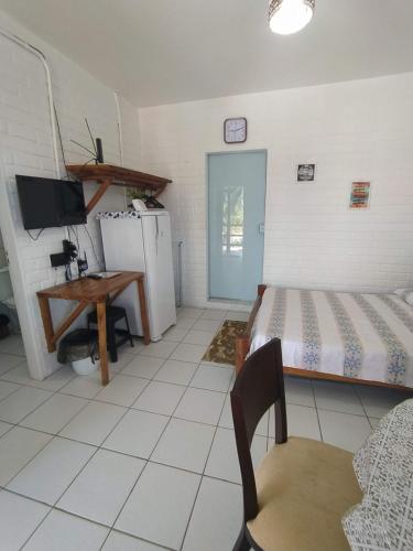 バヘイリーニャスにあるChalé em Porto dos Lençóis Residenceのベッドルーム(ベッド1台、デスク、テレビ付)