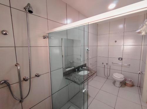 a bathroom with a shower and a sink and a toilet at Granville Hotel in Curitiba
