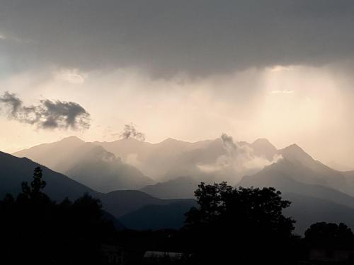 a view of a mountain range with the sun setting at B&B Tre Confini in Giaveno