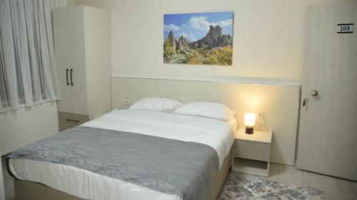 a bedroom with a bed and a painting on the wall at Trigo Hotel in Uçhisar