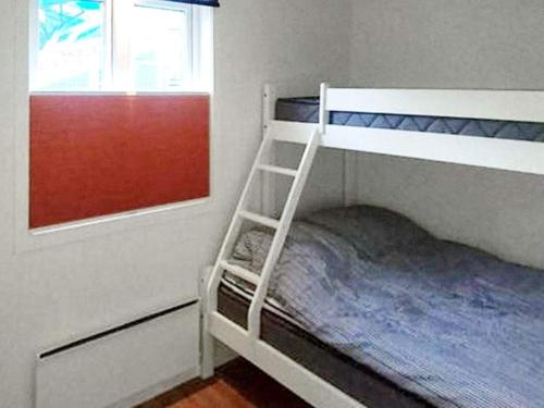 ein Etagenbett mit einer Leiter neben einem Fenster in der Unterkunft Holiday home STRÖMSTAD X in Strömstad