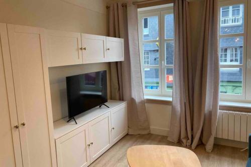 un salon avec une télévision à écran plat sur une armoire dans l'établissement Le petit pontépiscopien, à Pont-l'Évêque