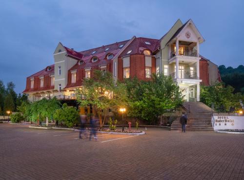 a large building with people walking in front of it at Mercure Medias Binderbubi Hotel And Spa in Mediaş