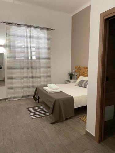 a white bedroom with a bed and a window at L’angolo delle bugie in Turi