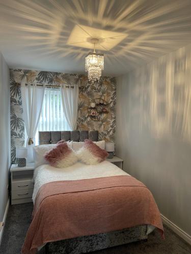 um quarto com uma cama grande e um lustre em The Courtyard em Donaghadee