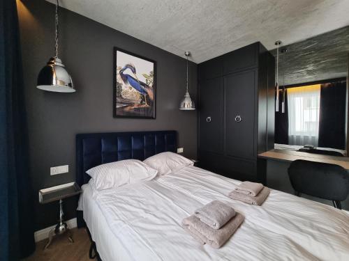 a bedroom with a large bed with two towels on it at Silesia Aparthotel in Szczecin