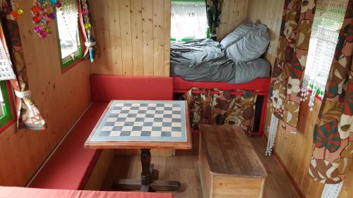 a chess table in a room with a bed at Roulotte Framboise in Vaux-en Couhé