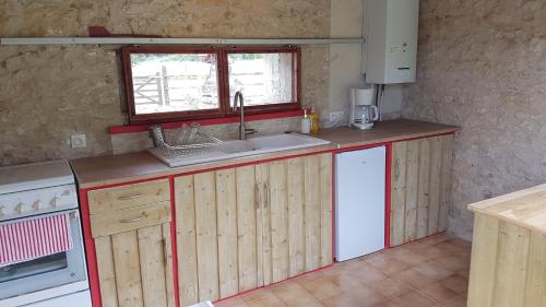 a kitchen with a sink and a counter top at Roulotte Framboise in Vaux-en Couhé