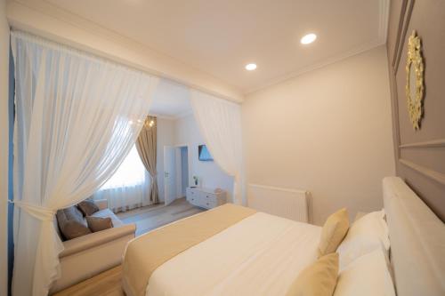 Habitación blanca con cama y sofá en BlueSky Ultra-Central Premium Apartment, en Oradea