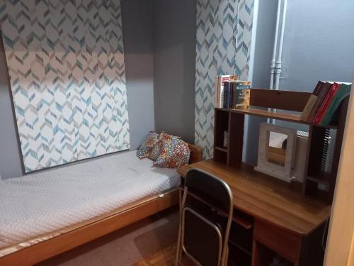 Cette petite chambre comprend un lit et un bureau. dans l'établissement Relaxation and Vacation with all the Comforts, à Athènes