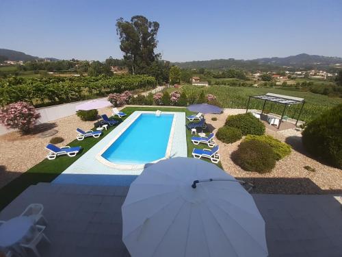 an overhead view of a swimming pool with chairs and umbrellas at As casinhas dos meus Avós by Quinta do Paço in Amarante