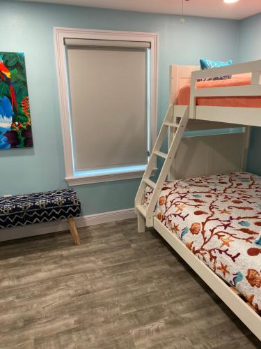 a bedroom with a bunk bed and a window at South Padre Island Beach House Retreat Downstairs in South Padre Island