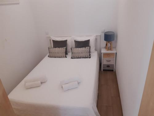 1 dormitorio con 1 cama blanca y 2 almohadas en As casinhas dos meus Avós by Quinta do Paço, en Amarante