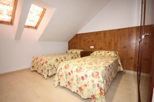 1 dormitorio con 2 camas y 2 ventanas en Apartamentos Rurales Campillo, en Arroyo Frío