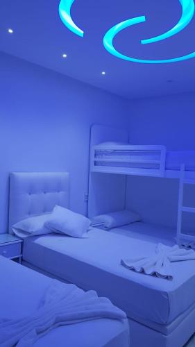 two beds in a room with blue lights on the ceiling at Apartamento Marina Smir in Tetouan