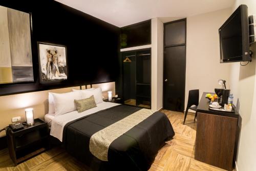 Rua Hoteles Piura في بيورا: غرفة فندقية بسرير وتلفزيون بشاشة مسطحة