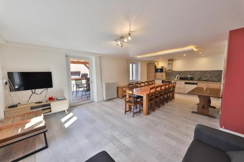 a living room with a dining table and a kitchen at Locations des 3 sommets avec Sauna et Spa en Alsace in Sondernach