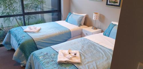 a bedroom with two beds with towels on them at Waterways Renaissance "A Touch Of Class" in Whitianga