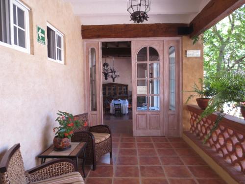 a porch of a house with chairs and a door at Hotel Boutique La Granja in Tequisquiapan