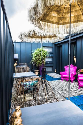 a patio with a table and chairs and an umbrella at Boutique Hotel Massimos in Námestovo
