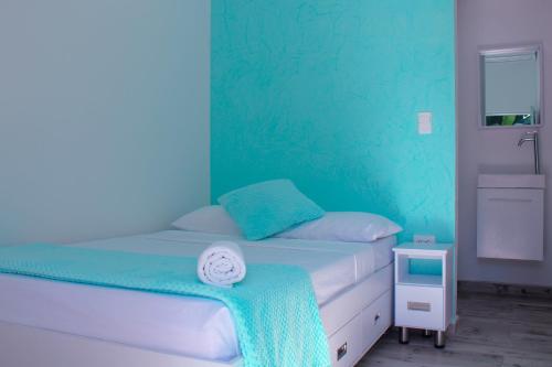 a bedroom with a bed with a blue wall at Victoria Imperial Hotel in Mariquita